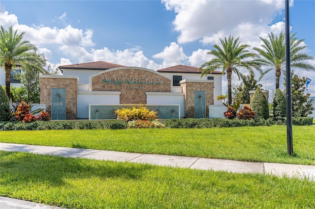 mediterranean / spanish-style house with a garage, stone siding, a front lawn, and stucco siding