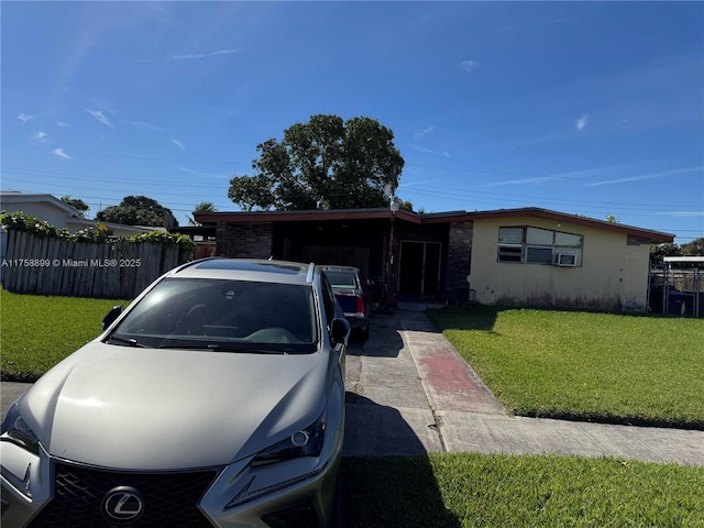 single story home featuring stucco siding, fence, and a front yard