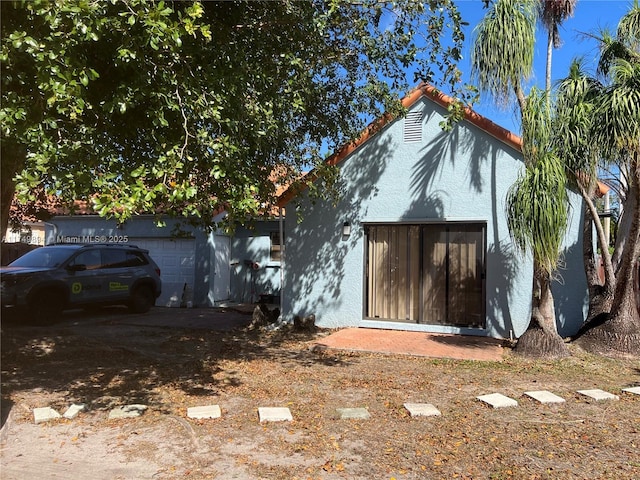 exterior space featuring a tile roof and stucco siding