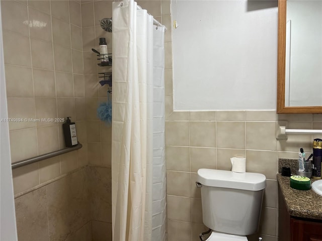 full bathroom featuring tiled shower, vanity, toilet, and tile walls