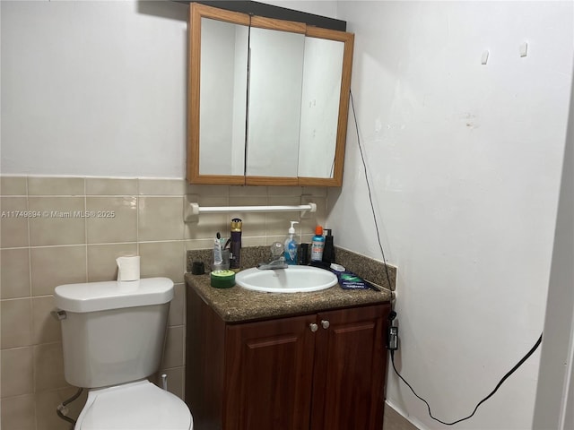 bathroom featuring vanity, toilet, and tile walls