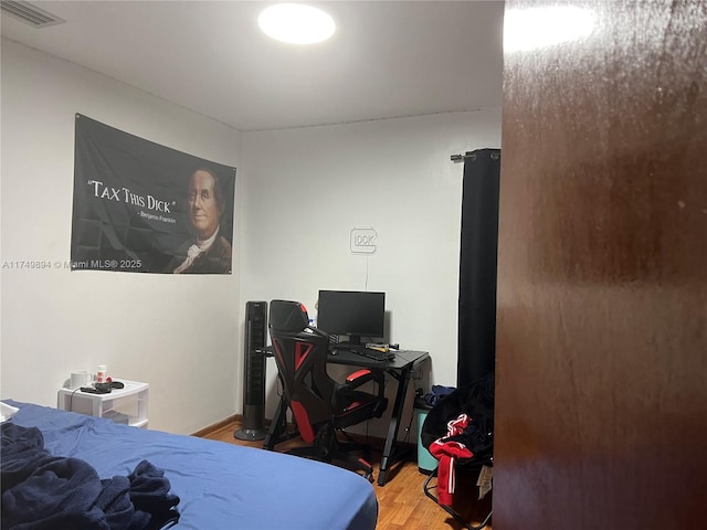 bedroom featuring wood finished floors and visible vents