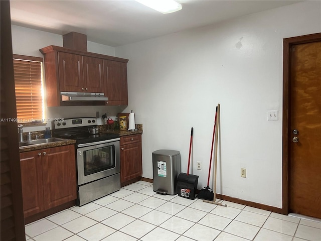 kitchen featuring electric range, dark countertops, under cabinet range hood, a sink, and light tile patterned flooring