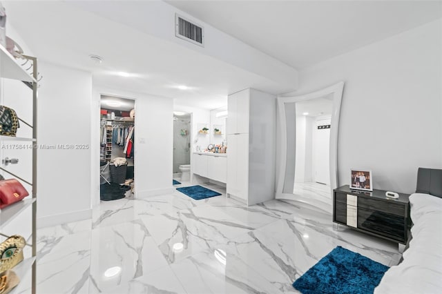 bedroom with visible vents, marble finish floor, a spacious closet, a closet, and ensuite bath
