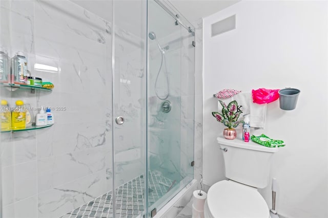 full bathroom featuring toilet and a marble finish shower