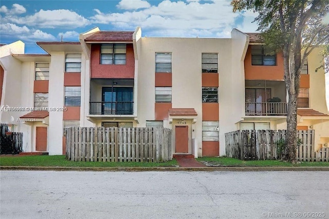 view of property with fence and stucco siding