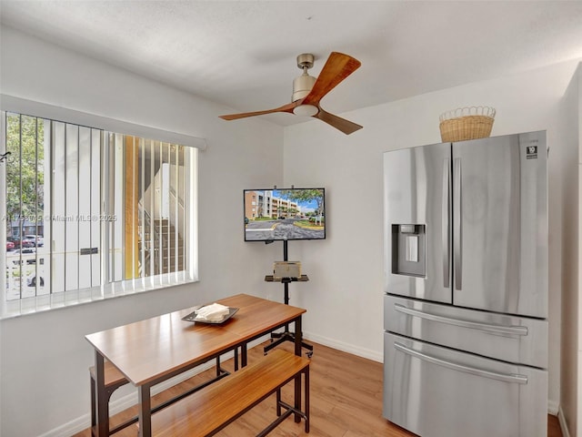 dining area with ceiling fan, baseboards, and light wood-style flooring