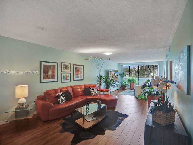 living area with a textured ceiling and wood finished floors