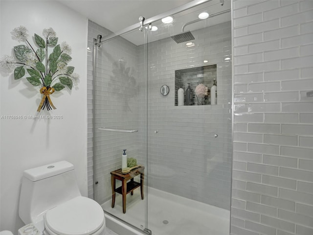 bathroom with a shower stall and toilet