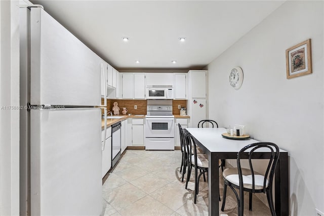 kitchen featuring light tile patterned floors, light countertops, decorative backsplash, white cabinetry, and white appliances