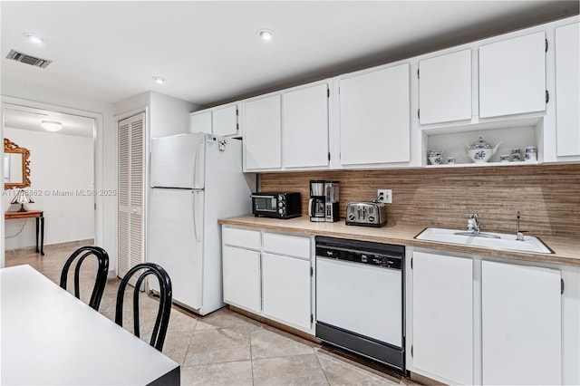 kitchen featuring light countertops, white appliances, and a sink
