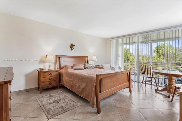 tiled bedroom with baseboards and access to exterior