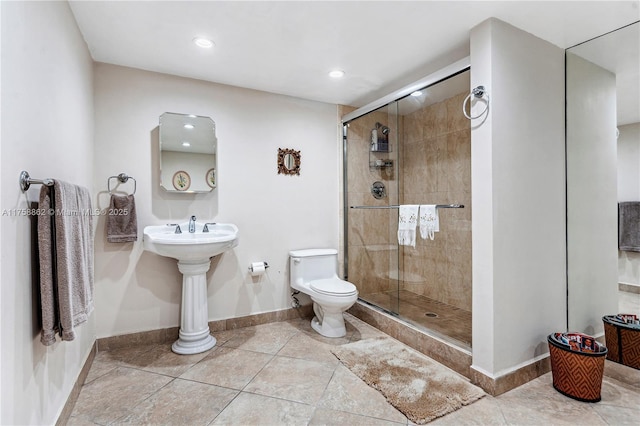 bathroom with a stall shower, tile patterned flooring, toilet, and baseboards