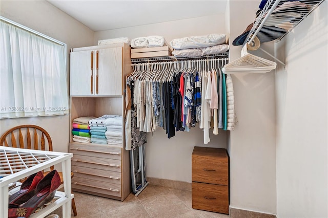 walk in closet with light tile patterned flooring
