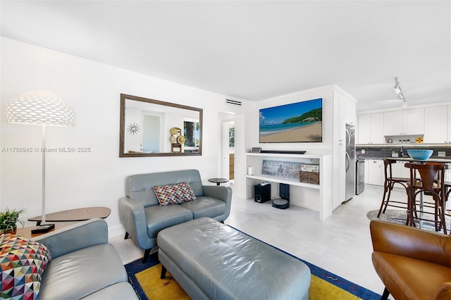 living room featuring visible vents and track lighting