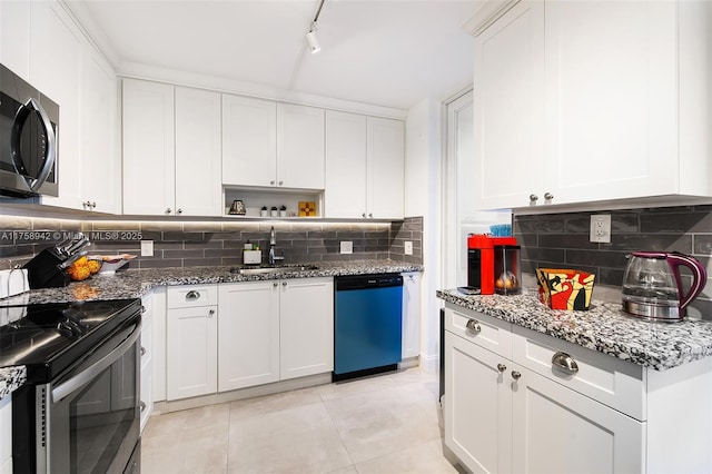 kitchen featuring stainless steel appliances, white cabinetry, a sink, and backsplash