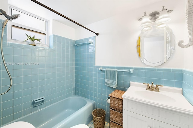 bathroom featuring wainscoting, toilet, bathtub / shower combination, vanity, and tile walls