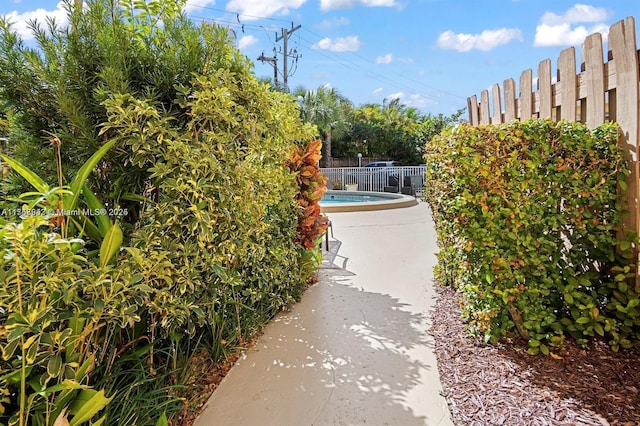 view of property's community featuring a swimming pool and fence