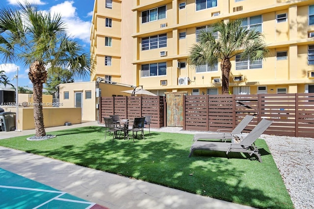 view of community featuring fence and a lawn