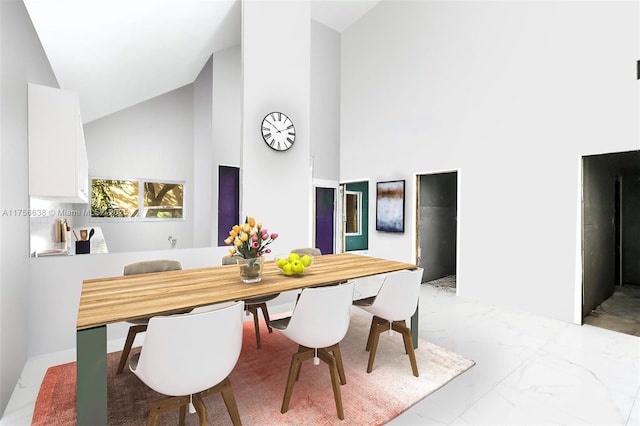 dining space with marble finish floor and high vaulted ceiling