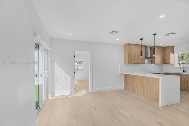 1116 N 31st Ave, Hollywood, FL 33021 - kitchen with wall chimney exhaust hood, light wood-style floors, light countertops, a peninsula, and recessed lighting