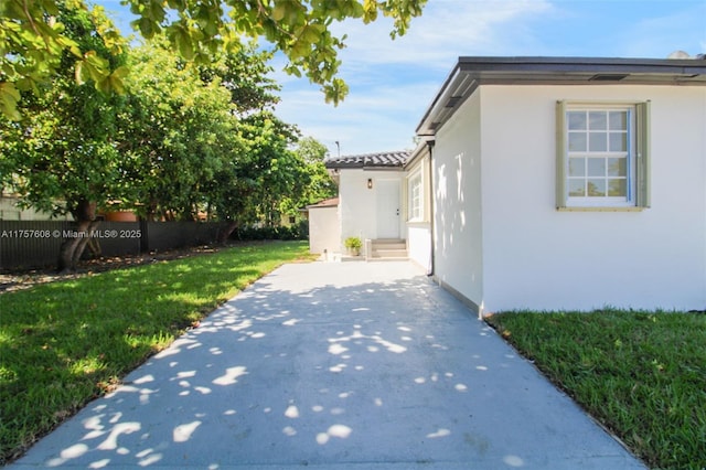 view of side of home with a yard and stucco siding