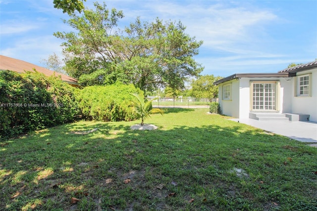 view of yard featuring entry steps and fence