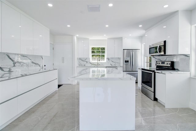 kitchen featuring marble finish floor, visible vents, modern cabinets, and appliances with stainless steel finishes