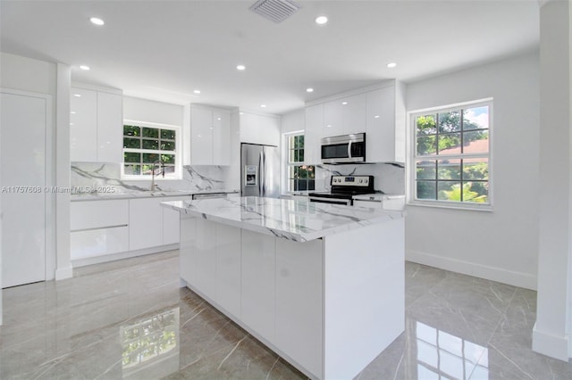 kitchen featuring marble finish floor, visible vents, modern cabinets, and appliances with stainless steel finishes