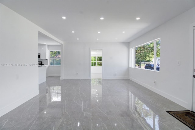 spare room with baseboards, marble finish floor, and recessed lighting