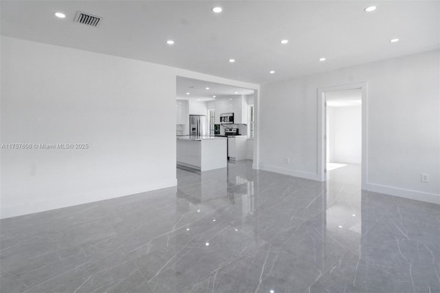 unfurnished living room with baseboards, marble finish floor, visible vents, and recessed lighting