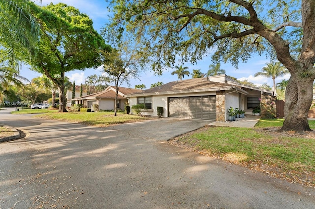 view of front of property with stone siding, driveway, and an attached garage