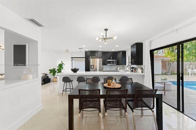 dining space with light tile patterned floors, visible vents, a chandelier, and recessed lighting