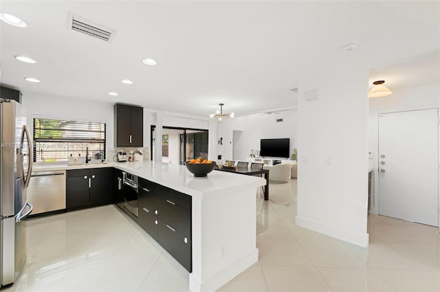 kitchen with light tile patterned floors, visible vents, appliances with stainless steel finishes, a peninsula, and light countertops