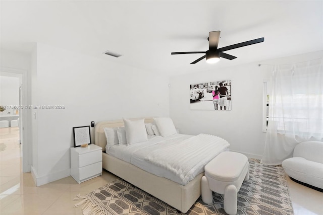 bedroom with a ceiling fan, visible vents, baseboards, and light tile patterned floors