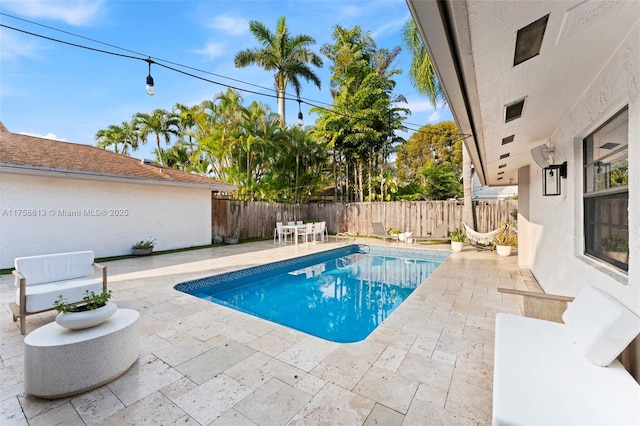 view of swimming pool with a fenced in pool, a fenced backyard, and a patio