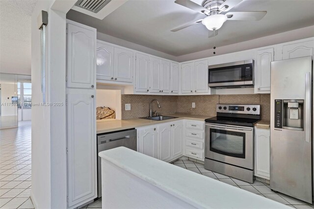 330 NE 26th Ave Unit 4160, Boynton Beach, FL 33435 - kitchen with stainless steel appliances, light tile patterned flooring, white cabinets, and decorative backsplash