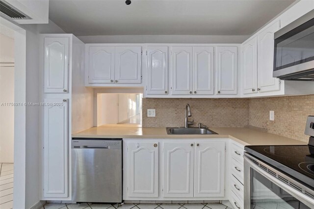 330 NE 26th Ave Unit 4160, Boynton Beach, FL 33435 - kitchen with appliances with stainless steel finishes, white cabinetry, and tasteful backsplash