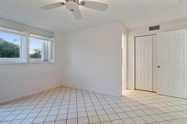 330 NE 26th Ave Unit 4160, Boynton Beach, FL 33435 - unfurnished bedroom featuring a textured ceiling, a closet, and a ceiling fan