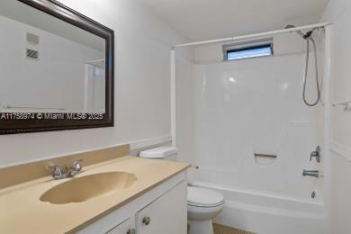 bathroom with vanity, toilet, and bathing tub / shower combination