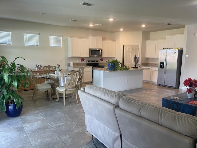 living area featuring recessed lighting and visible vents