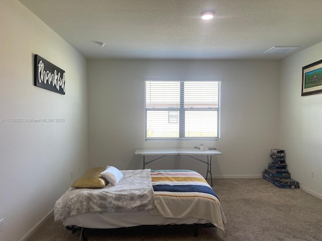 bedroom with carpet flooring, baseboards, visible vents, and a textured ceiling