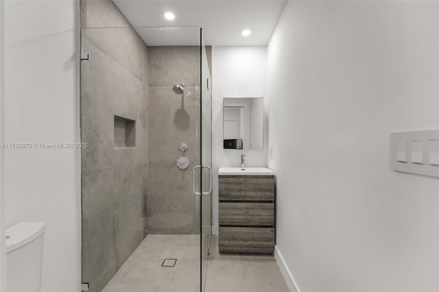 full bath featuring toilet, recessed lighting, a shower stall, baseboards, and vanity