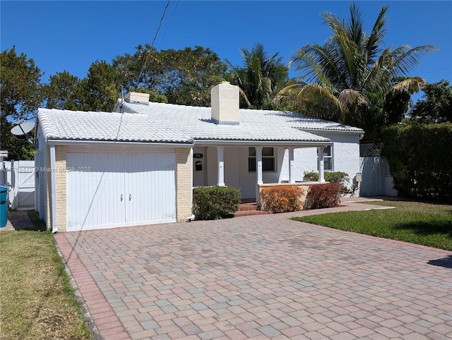 755 NE 88th St, Miami, FL 33138 - ranch-style home featuring a gate, decorative driveway, covered porch, a garage, and a chimney