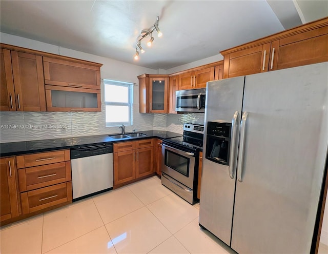 755 NE 88th St, Miami, FL 33138 - kitchen featuring light tile patterned floors, brown cabinetry, a sink, decorative backsplash, and appliances with stainless steel finishes