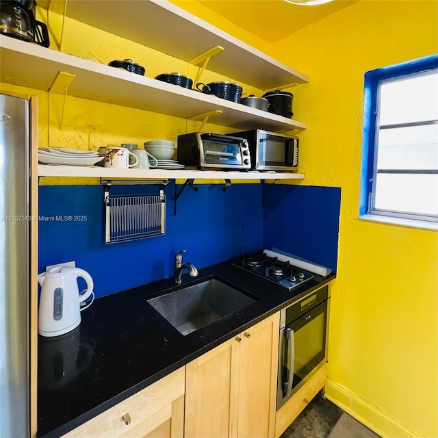 kitchen with wall oven, baseboards, gas stovetop, open shelves, and a sink