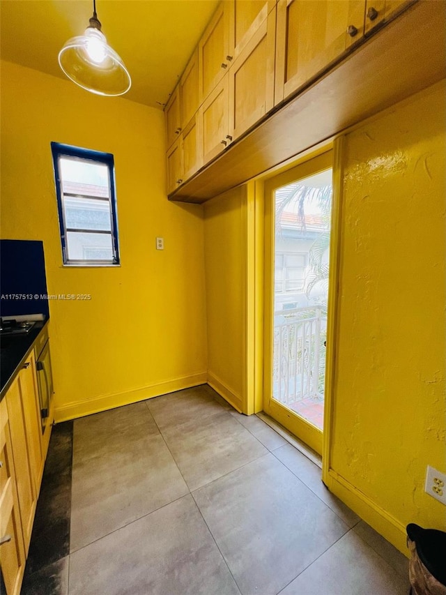 kitchen with dark countertops, decorative light fixtures, and baseboards