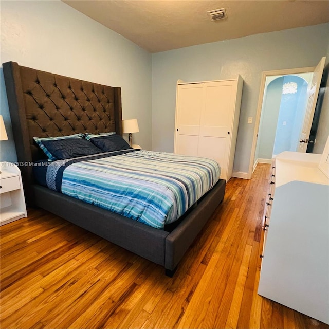 bedroom featuring wood-type flooring and visible vents