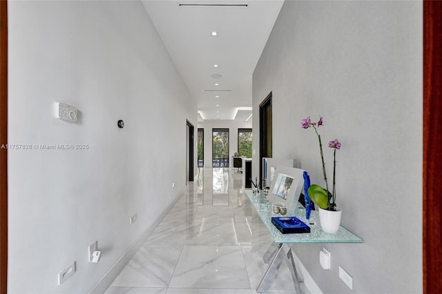 corridor featuring marble finish floor and baseboards