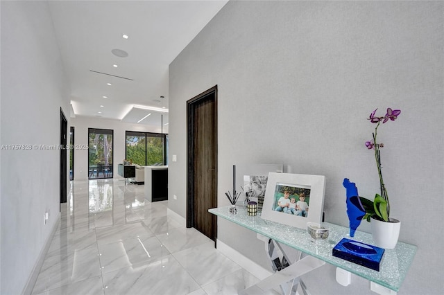 corridor featuring marble finish floor, baseboards, and recessed lighting